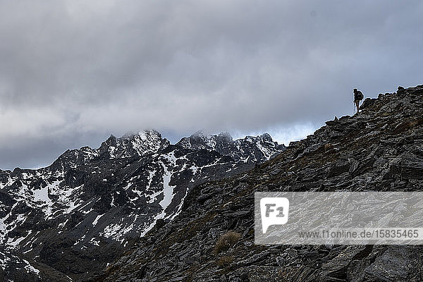 Figure on a rocky ridge  in the snowy mountains of New Zealand