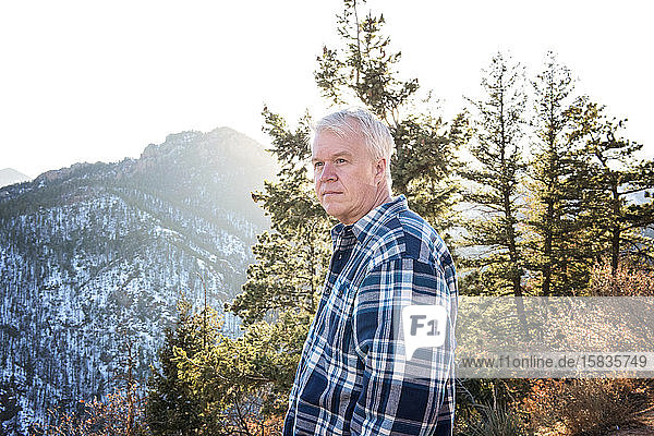 Älterer Mann blickt bei einer Bergwanderung in die Ferne