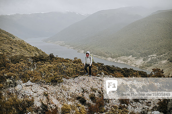 Frau wandert im Regen entlang eines Berges in der Nähe des Cobb-Reservoirs  Neuseeland