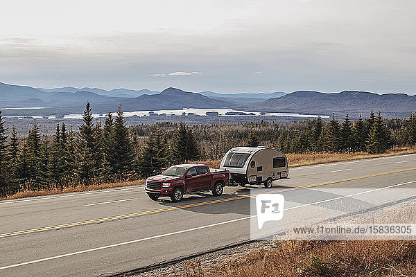 Pick-up und Wohnmobil fahren auf einer malerischen Straße in Jackman,  Maine