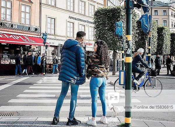 girlfriend and boyfriend waiting at a traffic light talking in Europe