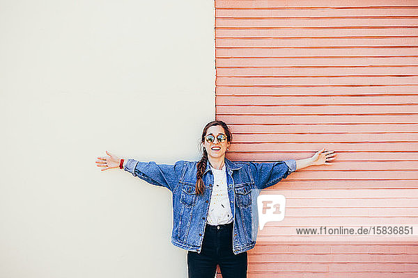 Attraktive junge Frau  die an einer zweifarbigen Wand lacht