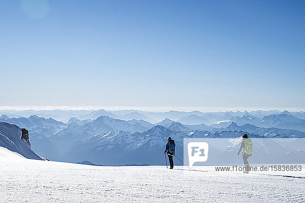 Zwei Bergsteigerinnen überqueren einen Gletscher auf dem Mt. Baker