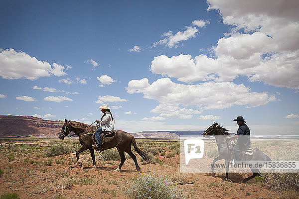 Cowboys überqueren eine offene Ebene in der Nähe des Monument Valley  Arizona
