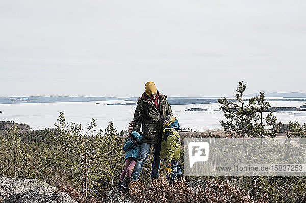 father and his kids enjoying hiking together and the ocean view