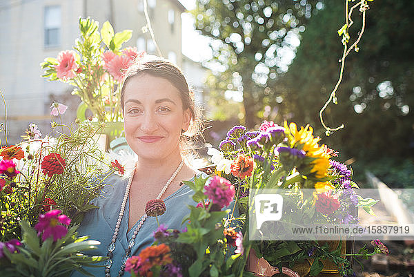 glückliche Frau in einem Blumengarten bei Sonnenschein