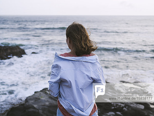 Junge Frau schaut auf den Ozean