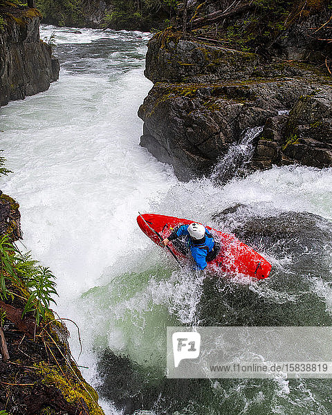 A white water kayaker paddles over a waterfall on the Cheakamus River.