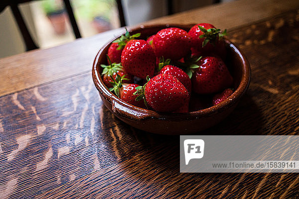 Schale mit Erdbeeren auf einem Holztisch