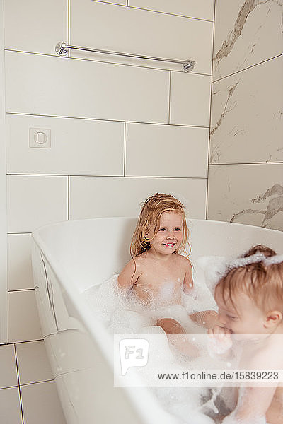 kleiner Bruder und kleine Schwester baden in einem Schaumbad