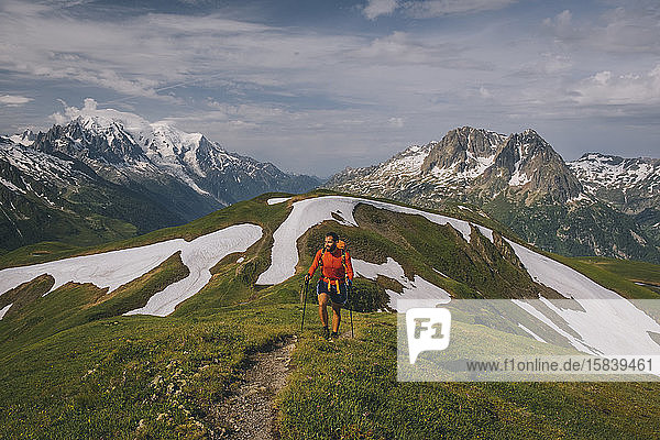 Junge Männer wandern in den französischen Alpen mit dem Mont Blanc als Kulisse.