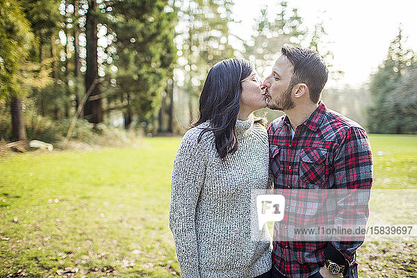 Confident  attractive couple kissing outdoors.
