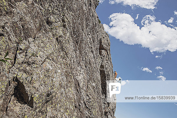 Zwei Menschen klammern sich beim Felsklettern am Rand einer Klippe fest  Wyoming