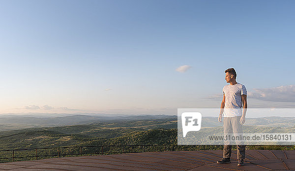 Adult man looks at the panorama of the mountains  in summer