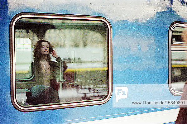 Eine Frau steht in der Nähe eines Zuges auf einem Bahnhof