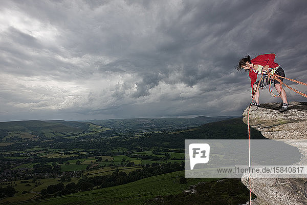 Weibliche Felskletterin auf einer Klippe im Peak District in England