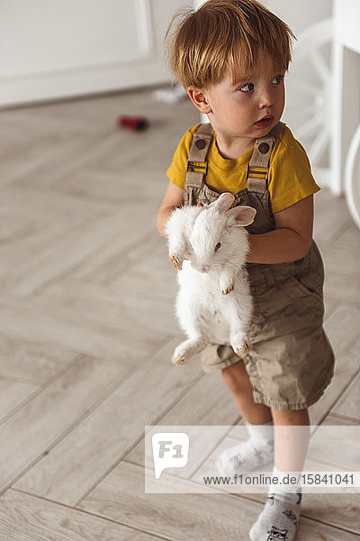 Junge spielt zu Ostern mit einem Kaninchen