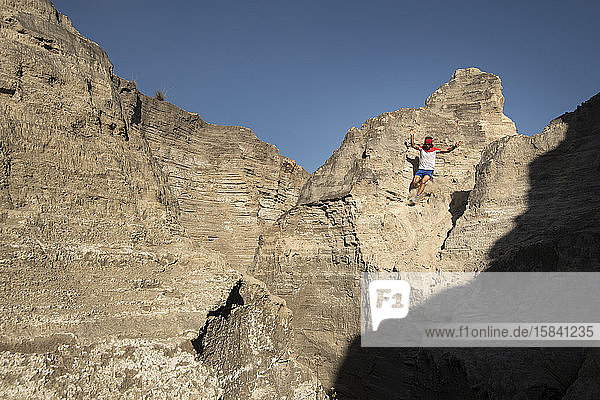 Ein Mann steigt auf einem sandigen und steilen Gelände in einem alten Bergbaugebiet ab