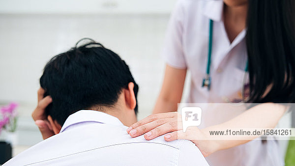 Doctor comforting patient at consulting room.