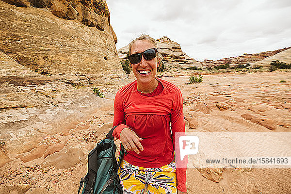 Wüstenwanderer mit schräger Sonnenbrille und durcheinandergeworfenem Hemd lachend
