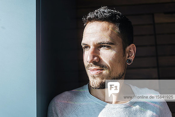 Hübscher hispanischer Mann zu Hause  der zur Seite schaut  entspannte Profil-Pose