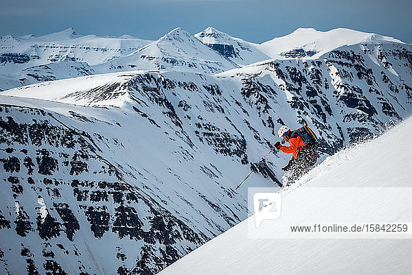 Ein Mann fährt tagsüber auf einem Berg in Island Ski