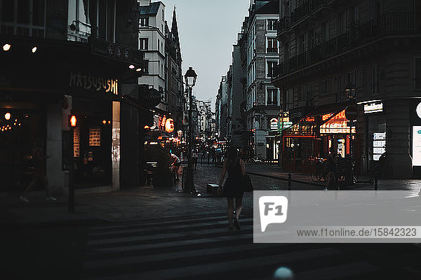 Nächtliche Straße in Paris mit Stadtlichtern und Stadtleben