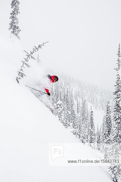 Ein männlicher Skifahrer findet im kanadischen Hinterland Tiefschnee.