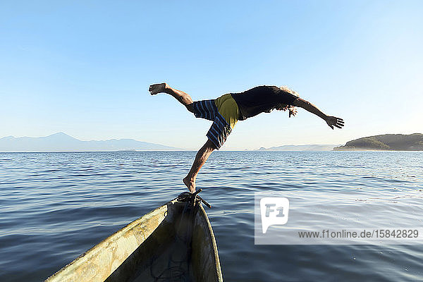 Mann springt vom Boot ins Meer