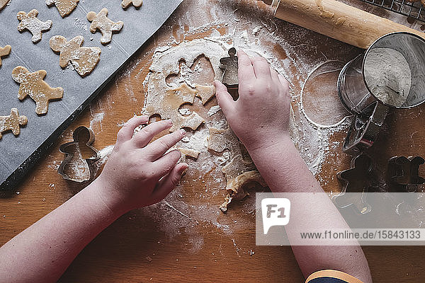 Boy cutting out gingerbread from dough