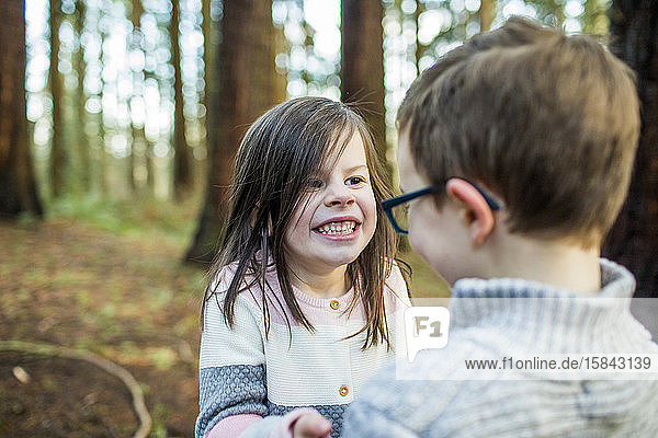 Verspielte Jungen und Mädchen genießen die Zeit draußen im Wald.