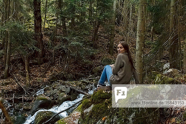 Girl traveler in the background of a mountain stream