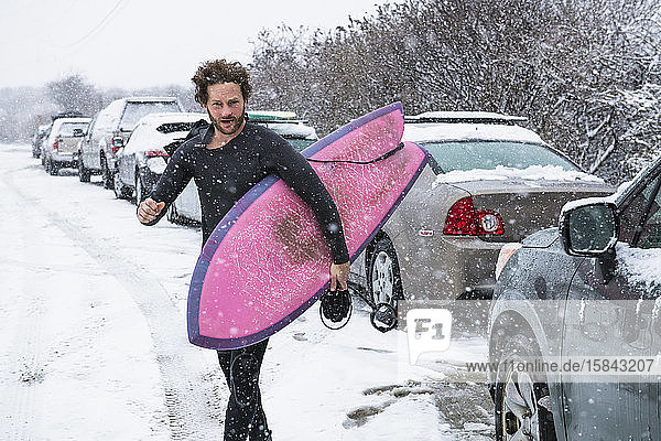 Mann bereitet sich darauf vor, im Winterschnee surfen zu gehen