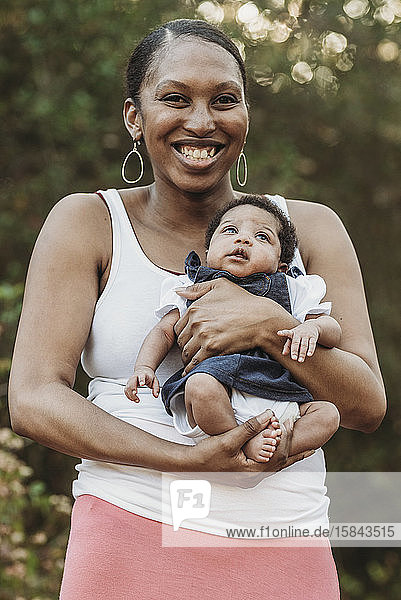 Close up portrait of young mother holding newborn age daughter