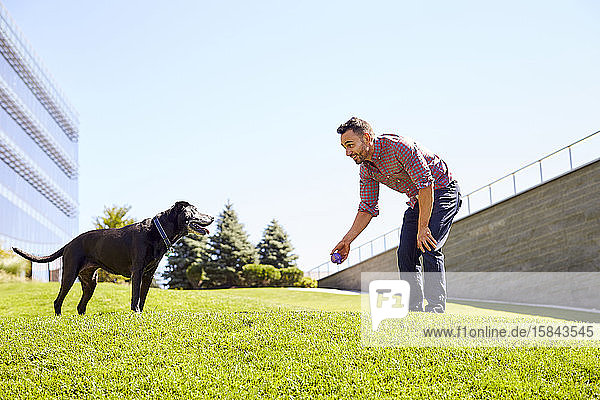 Ein Mann spielt mit seinem Hund.