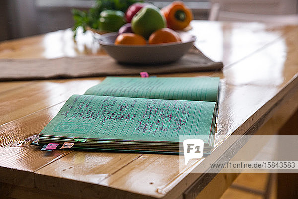 Gewürze und altes Rezeptbuch auf Holzuntergrund auf Küche.
