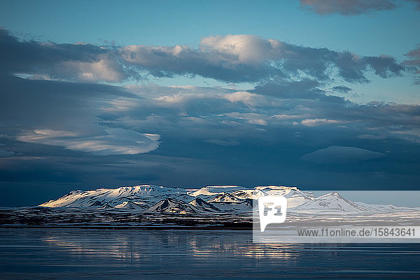 Berge entlang eines Sees in Island mit launischen Wolken
