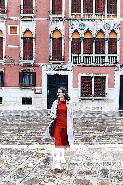 junger Tourist in Kleid und Mantel auf den Straßen von Venedig
