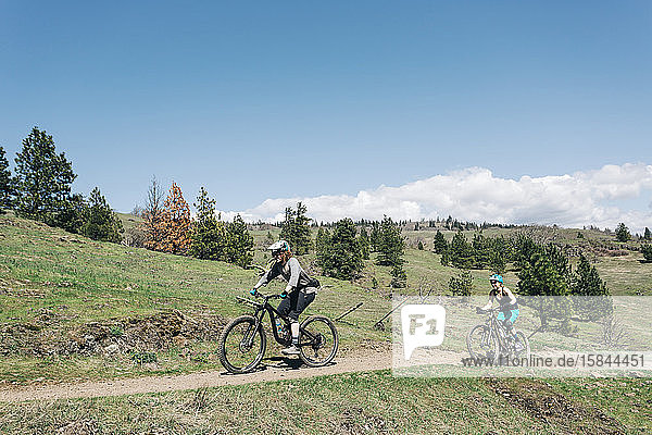 Two bilers pedal along a trail in Washington State.