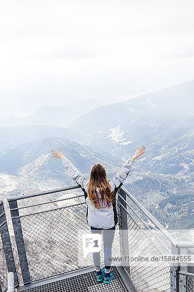 junges Mädchen geniesst die Aussicht auf die Alpen von der Aussichtsplattform