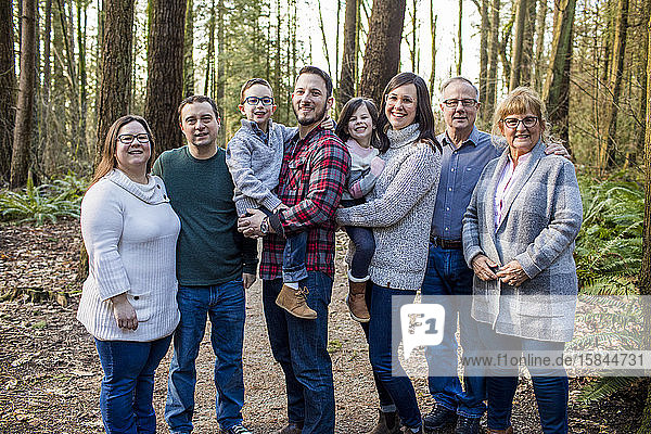 Portrait of happy family in forest setting.