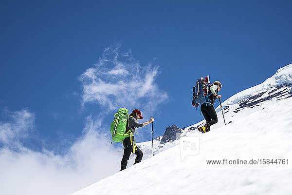 Zwei Bergsteigerinnen wandern oberhalb der Wolkenlinie auf Mt. Baker  WA