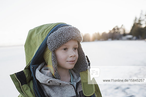 portrait of boy at the beach at sunset in winter