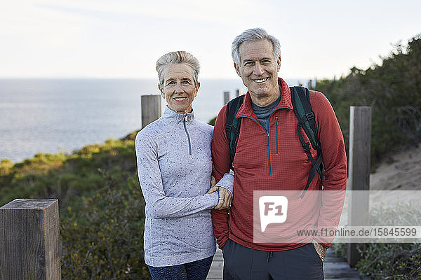Portrait of smiling couple standing against sea