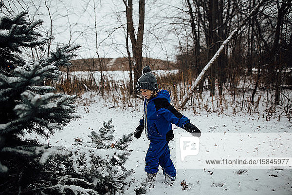 Little boy in snowsuit playing in snow during the winter