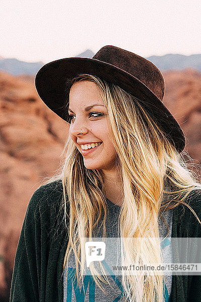 Bildnis eines weiss lächelnden Mädchens mit Hut und blonden Haaren