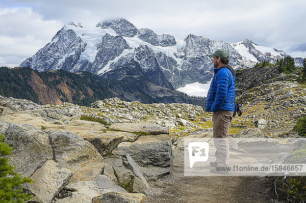 Male Hiking In The Alpine With Glacier Covered Mountain