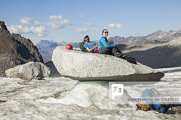 Ehepaar sitzt auf Fels  Snowbird Glacier  Talkeetna-Gebirge  Alaska