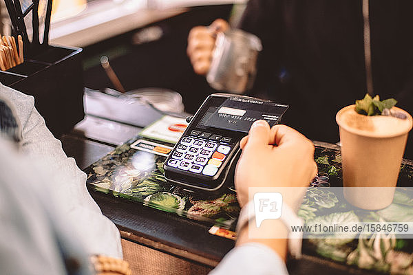 Kunde bezahlt mit Kreditkarte und kauft Kaffee im Café