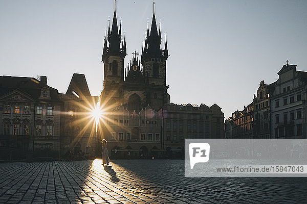Frau  die bei Sonnenaufgang auf dem Altstadtplatz spazieren geht  in Prag  Tschechien.